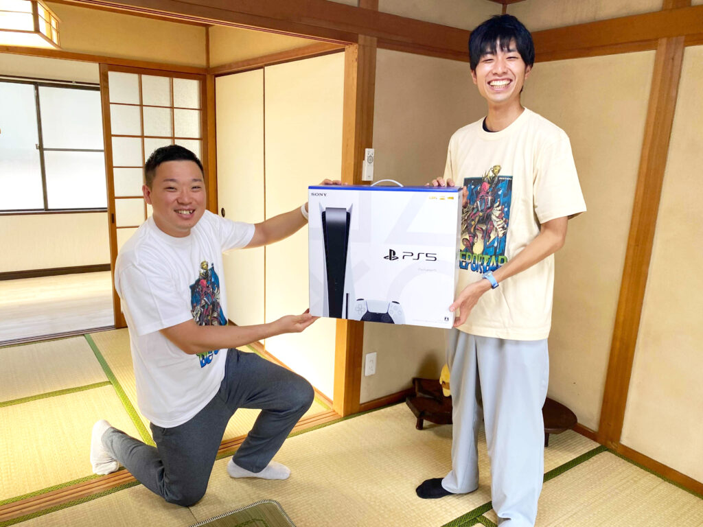 岡山・中四国eスポーツ企画会社DEPORTAR（デポルターレ）代表山田浩徳から、岡山のフリースクールもえぎ代表中藤寛人氏に『PlayStation 5』が贈呈されている写真です。